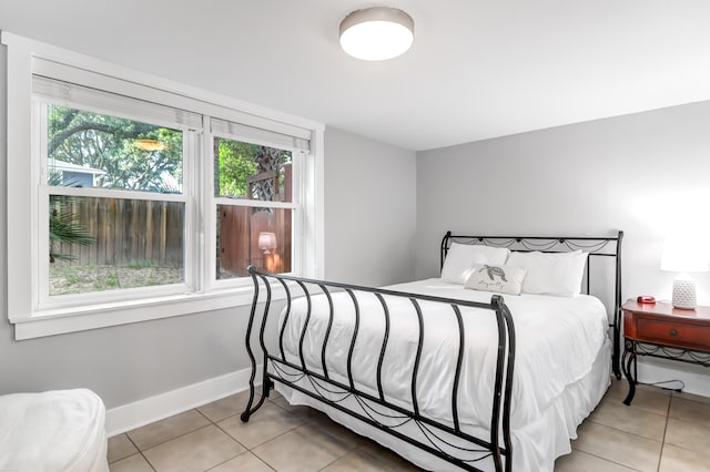 bedroom with light tile patterned flooring and baseboards