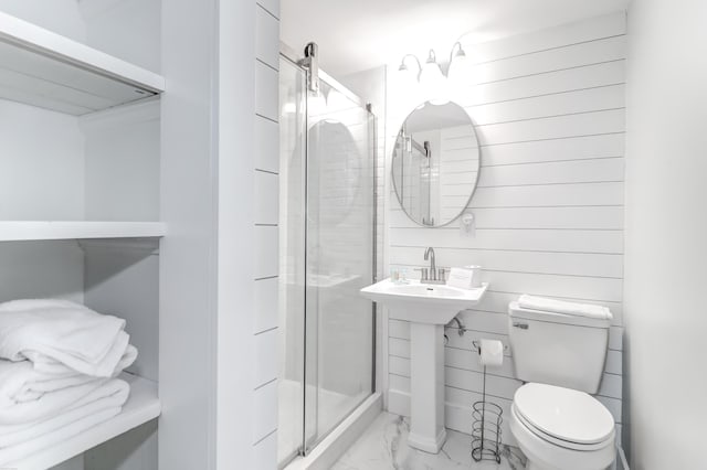 bathroom with toilet, marble finish floor, and a stall shower