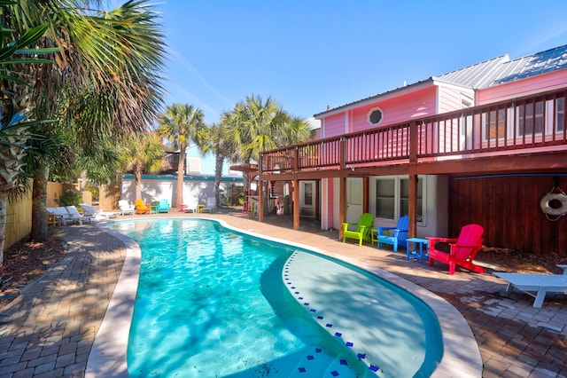 view of pool with a fenced in pool, a patio area, fence, and a wooden deck