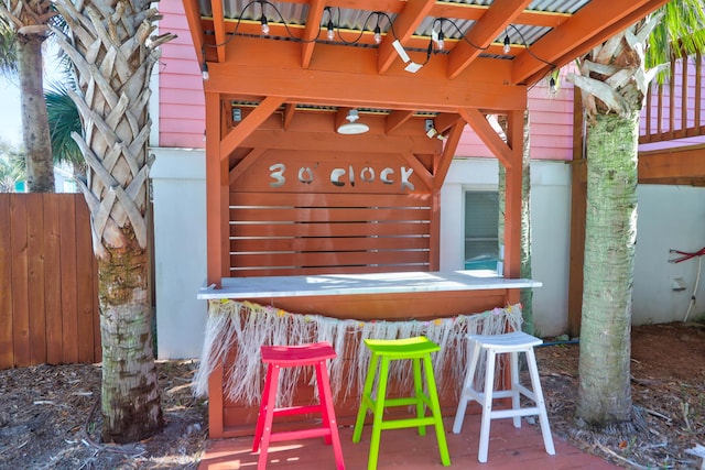 view of patio featuring outdoor dry bar and fence