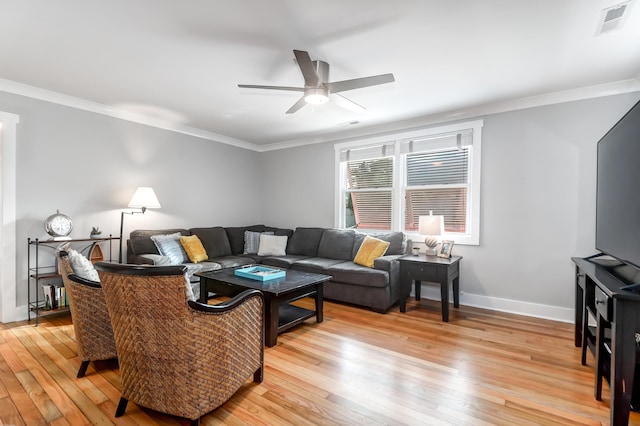 living room featuring visible vents, ornamental molding, ceiling fan, light wood-type flooring, and baseboards