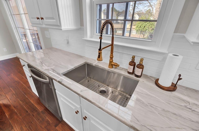 kitchen featuring dark hardwood / wood-style floors, white cabinetry, sink, decorative backsplash, and stainless steel dishwasher