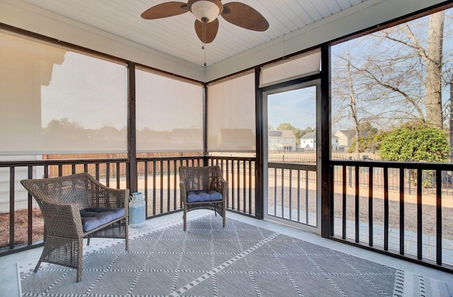 unfurnished sunroom with ceiling fan