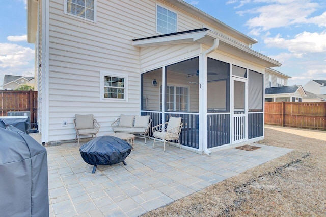 view of patio featuring a sunroom, a grill, and a fire pit