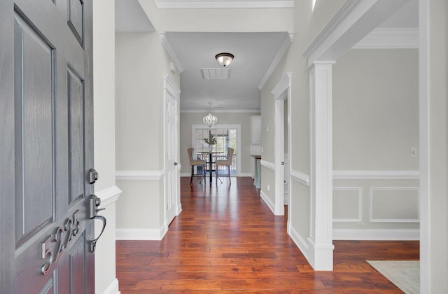 entrance foyer with ornate columns, ornamental molding, and dark hardwood / wood-style flooring