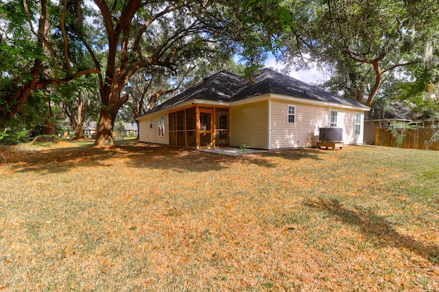 rear view of house featuring a lawn, a sunroom, and cooling unit