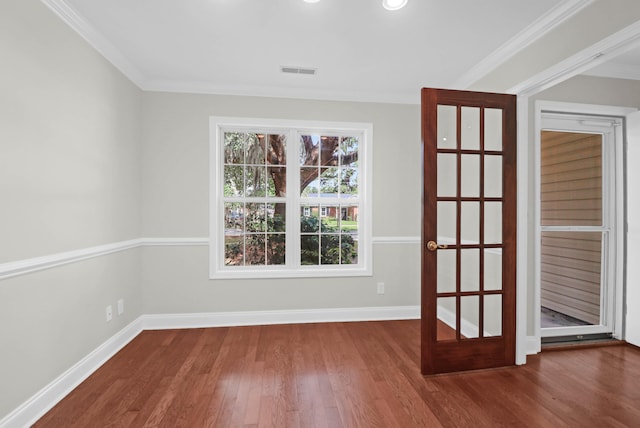 empty room featuring wood-type flooring, french doors, and crown molding