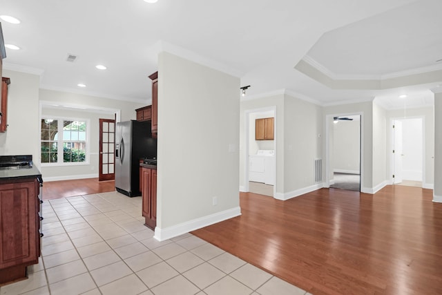 kitchen featuring ornamental molding, washer and clothes dryer, ceiling fan, light tile patterned floors, and stainless steel fridge with ice dispenser