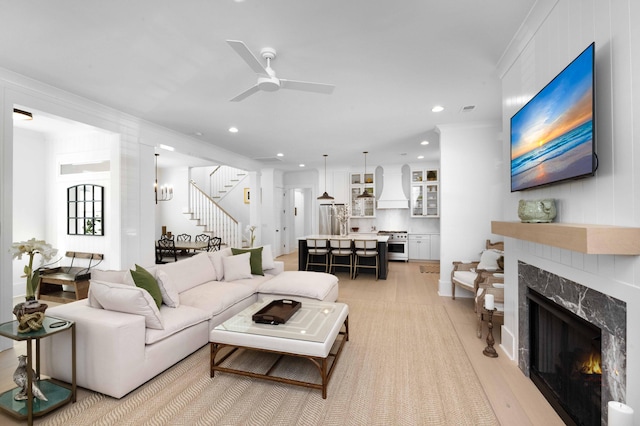 living room featuring visible vents, recessed lighting, a premium fireplace, ceiling fan, and stairs