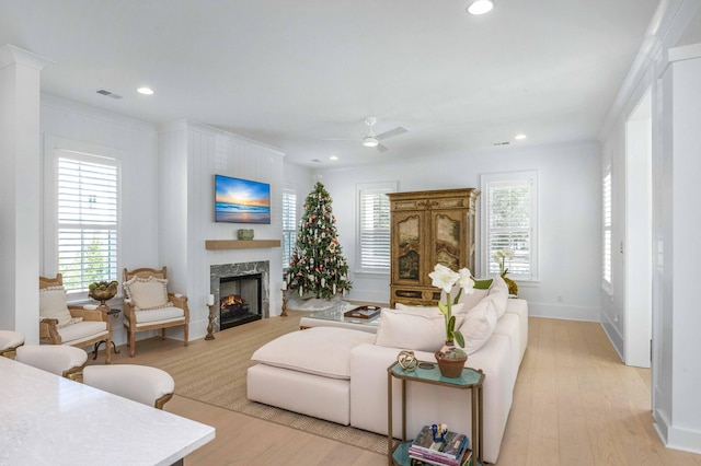 living room featuring recessed lighting, visible vents, a high end fireplace, and light wood finished floors