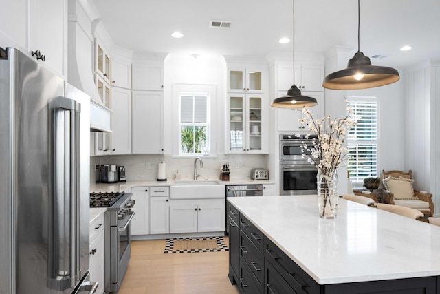 kitchen with a sink, light countertops, white cabinets, and stainless steel appliances