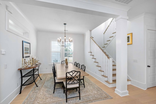 dining space featuring stairway, an inviting chandelier, baseboards, and light wood-style floors