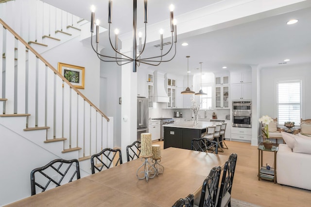 dining space featuring visible vents, recessed lighting, stairs, and light wood-type flooring