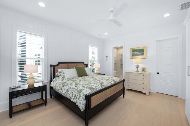 bedroom with light wood-style floors, visible vents, and ornamental molding