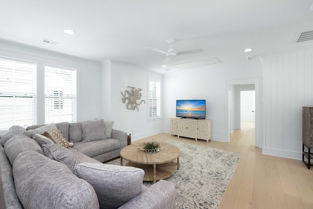 living room featuring light wood-style floors, visible vents, and a wealth of natural light