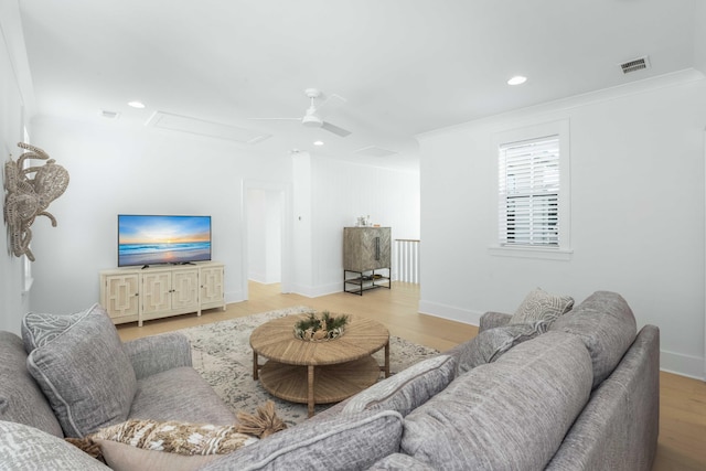 living room with visible vents, recessed lighting, attic access, and light wood-style floors