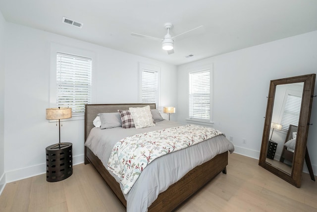 bedroom featuring visible vents, light wood-style flooring, baseboards, and ceiling fan