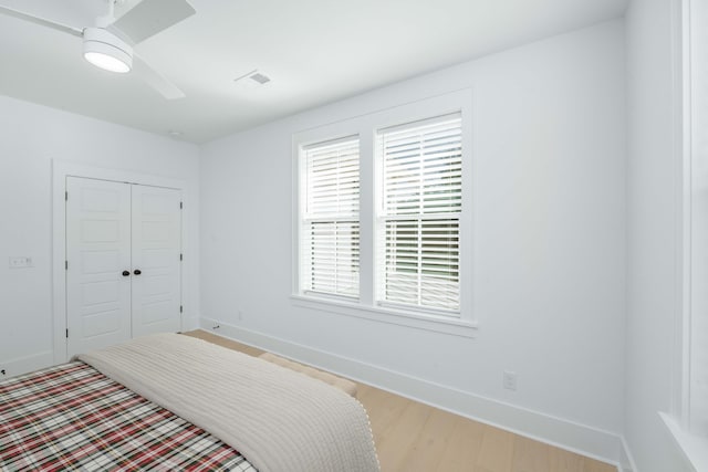 bedroom with visible vents, baseboards, a closet, and wood finished floors