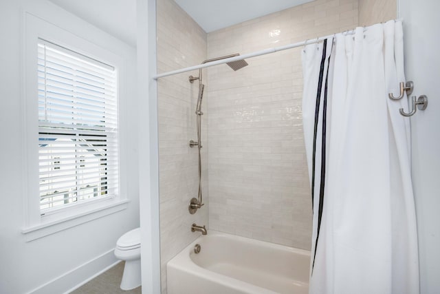 full bath featuring toilet, baseboards, and shower / bath combo