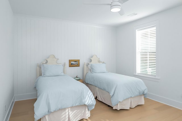 bedroom with visible vents, baseboards, a ceiling fan, and wood finished floors