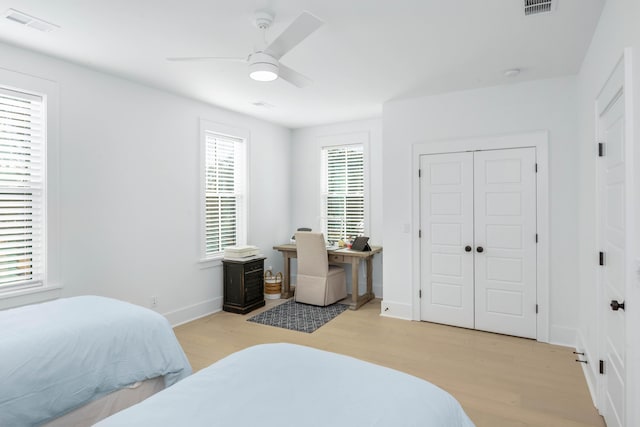 bedroom featuring baseboards, light wood-style floors, and a ceiling fan