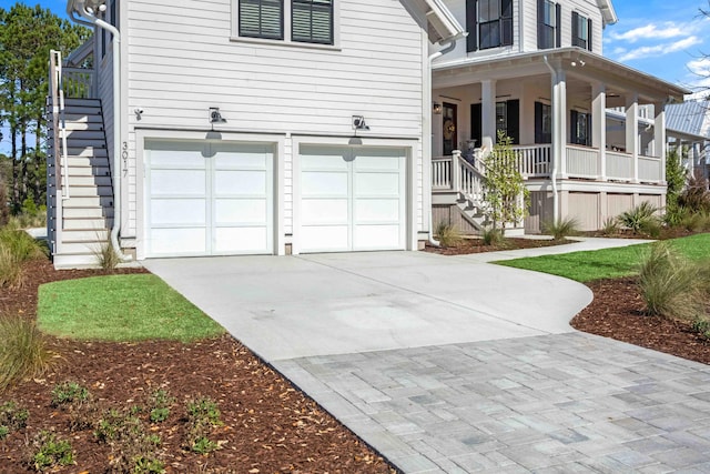 view of front of house featuring stairs, a garage, covered porch, and driveway