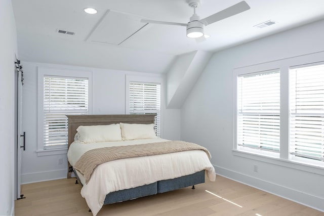 bedroom with light wood-style flooring, multiple windows, and visible vents