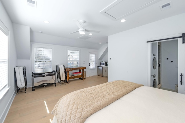 bedroom featuring visible vents, recessed lighting, stacked washing maching and dryer, and light wood-style floors