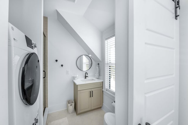 bathroom featuring vanity, washer / dryer, toilet, and a stall shower