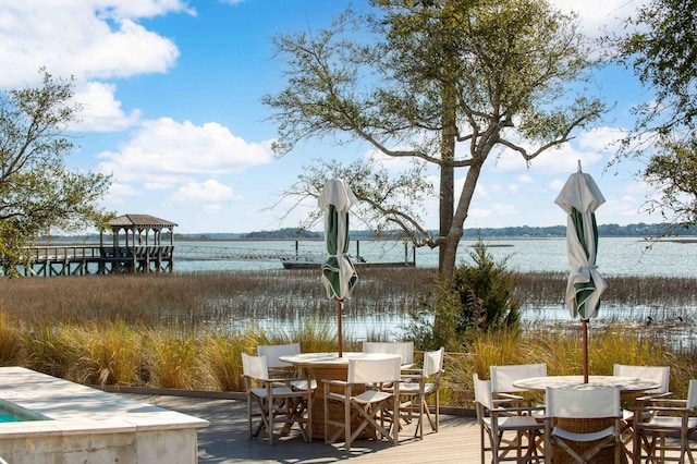 exterior space featuring a water view and outdoor dining space