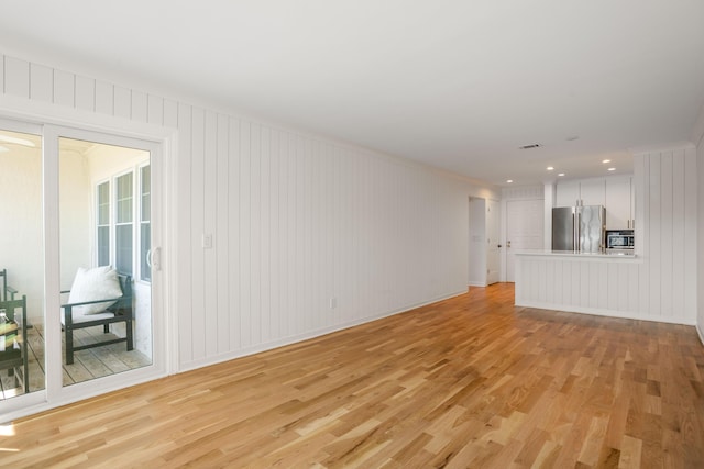 unfurnished living room with light wood finished floors and visible vents