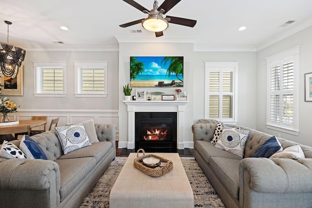 living room with hardwood / wood-style flooring, ceiling fan, and ornamental molding