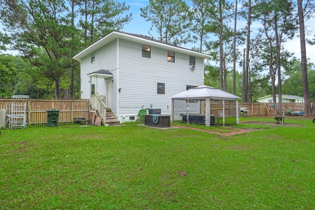 back of property featuring a gazebo and a lawn