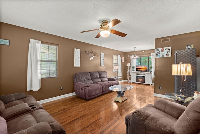 living room featuring ceiling fan, a textured ceiling, and hardwood / wood-style flooring