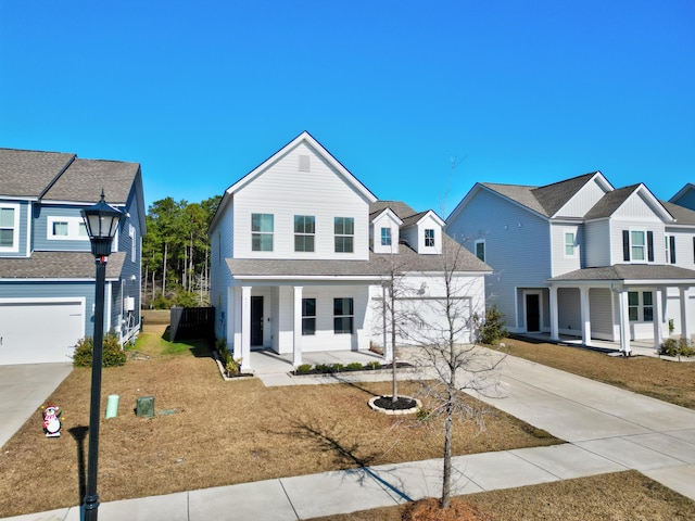 view of front of property featuring a front lawn, a porch, and a garage