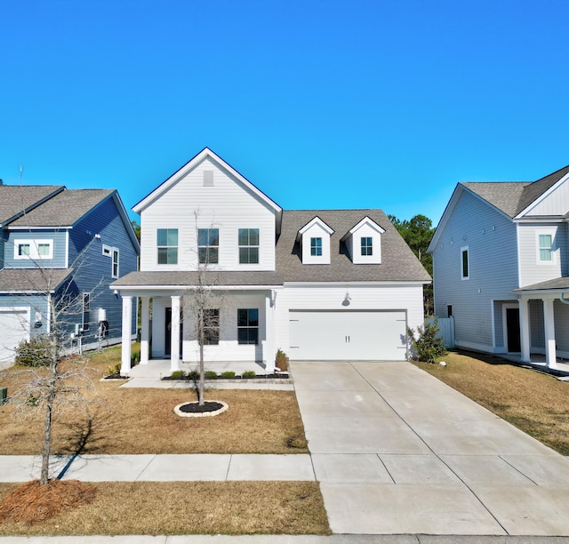 view of front of property featuring a front lawn, covered porch, and a garage