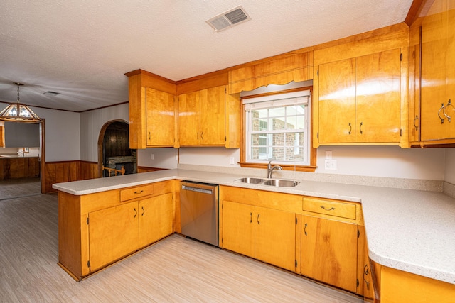 kitchen with a sink, a peninsula, visible vents, dishwasher, and light countertops