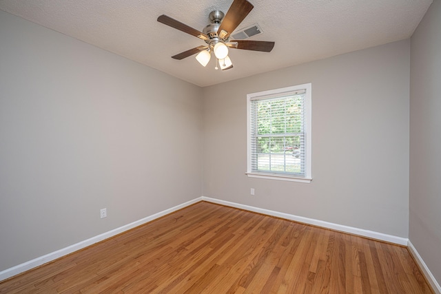 empty room featuring light wood-type flooring, visible vents, baseboards, and ceiling fan