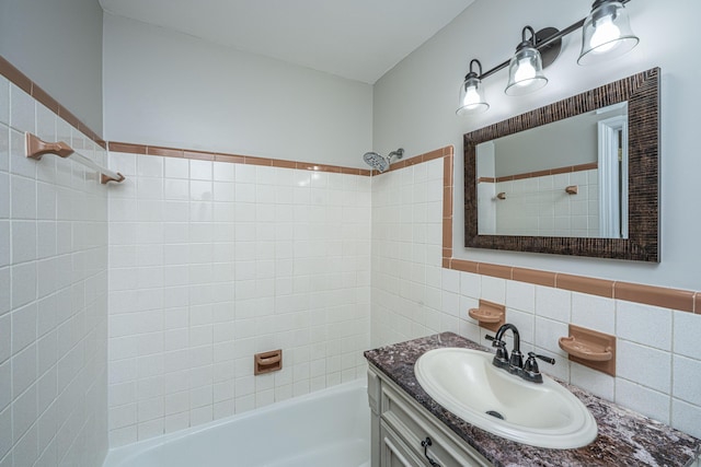 bathroom with tile walls, bathing tub / shower combination, and vanity