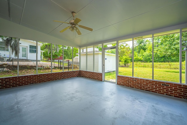unfurnished sunroom featuring a ceiling fan