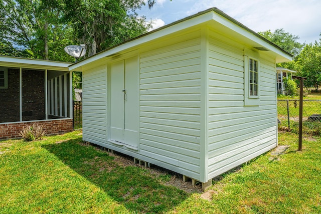 view of shed with a sunroom and fence