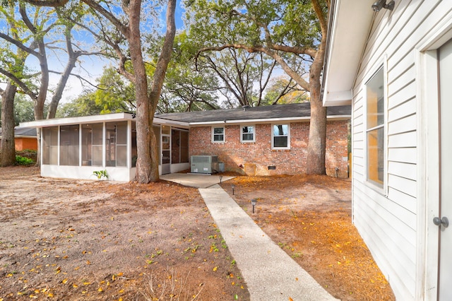 back of property featuring cooling unit, a sunroom, and a patio