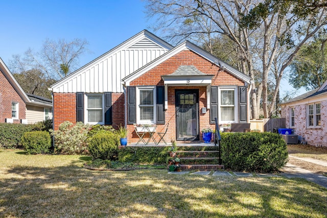 bungalow with brick siding, board and batten siding, and a front yard