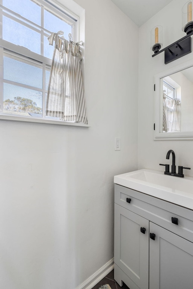 bathroom with a wealth of natural light, vanity, and baseboards