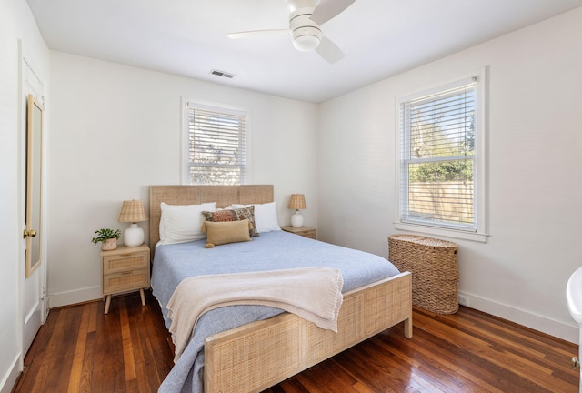 bedroom featuring a ceiling fan, baseboards, visible vents, and hardwood / wood-style floors