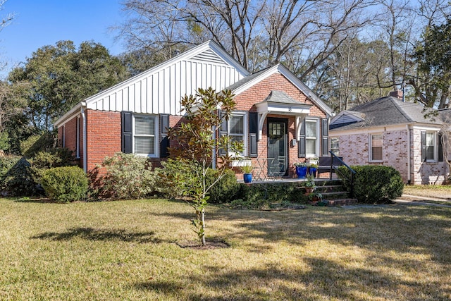 view of front facade featuring a front lawn, board and batten siding, and brick siding