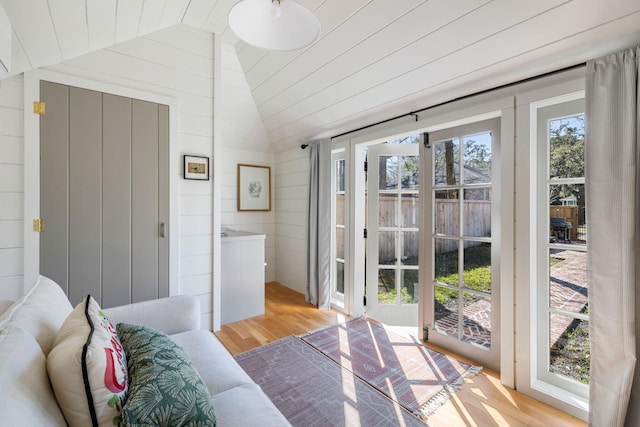 doorway with vaulted ceiling and light wood-style floors