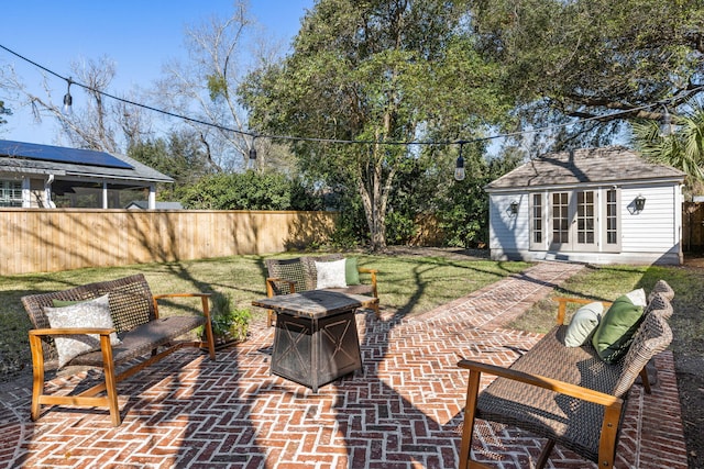 view of patio featuring an outbuilding, a storage structure, a fire pit, and fence