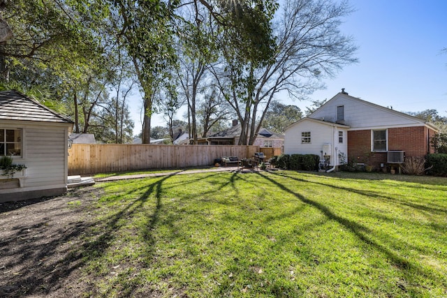 view of yard with central air condition unit and fence