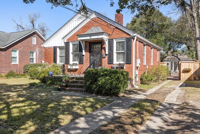 view of front of property with a front yard, a chimney, board and batten siding, and brick siding